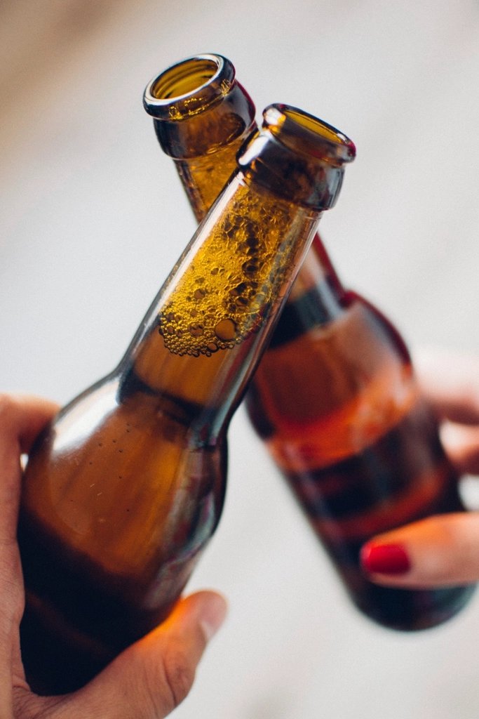 Dos botellas de cerveza brindando en primer plano